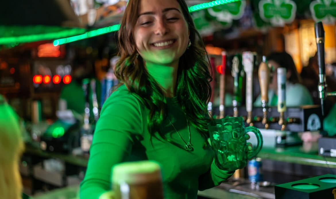 Une bartender servant un bière avec un sourire radieux au Pub Glen Morgan's